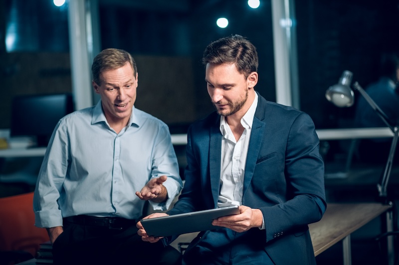 Two colleagues reviewing work on a tablet